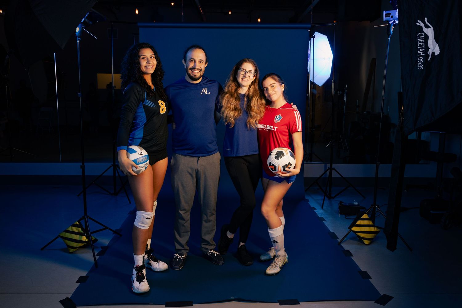 Soccer team photo shoot with players and coach in studio setting.