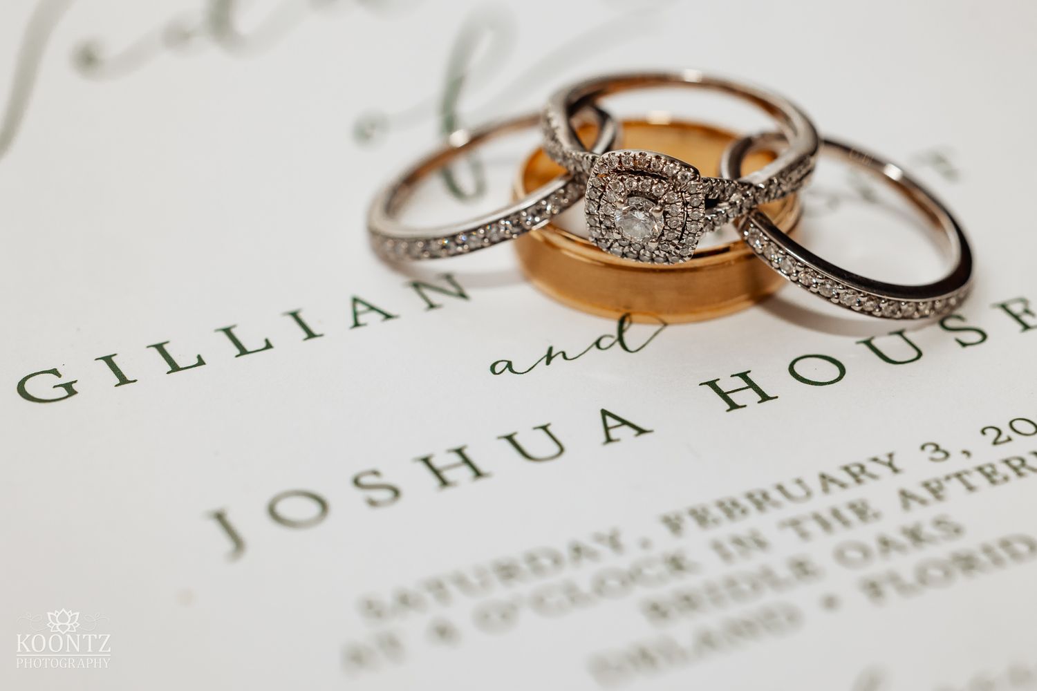 Diamond engagement ring and wedding bands resting on a wedding invitation for Gillian and Joshua House.