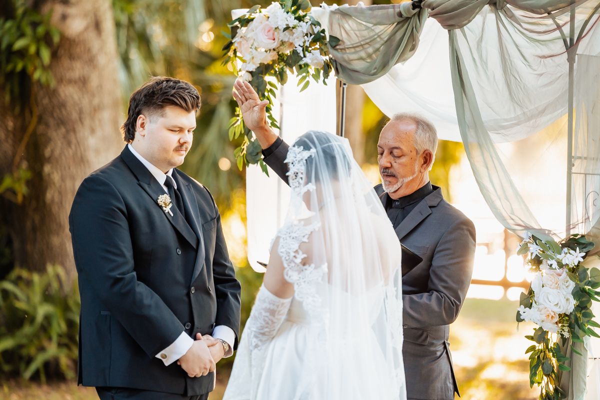Wedding ceremony moments captured under a floral arch with golden sunlight filtering through.
