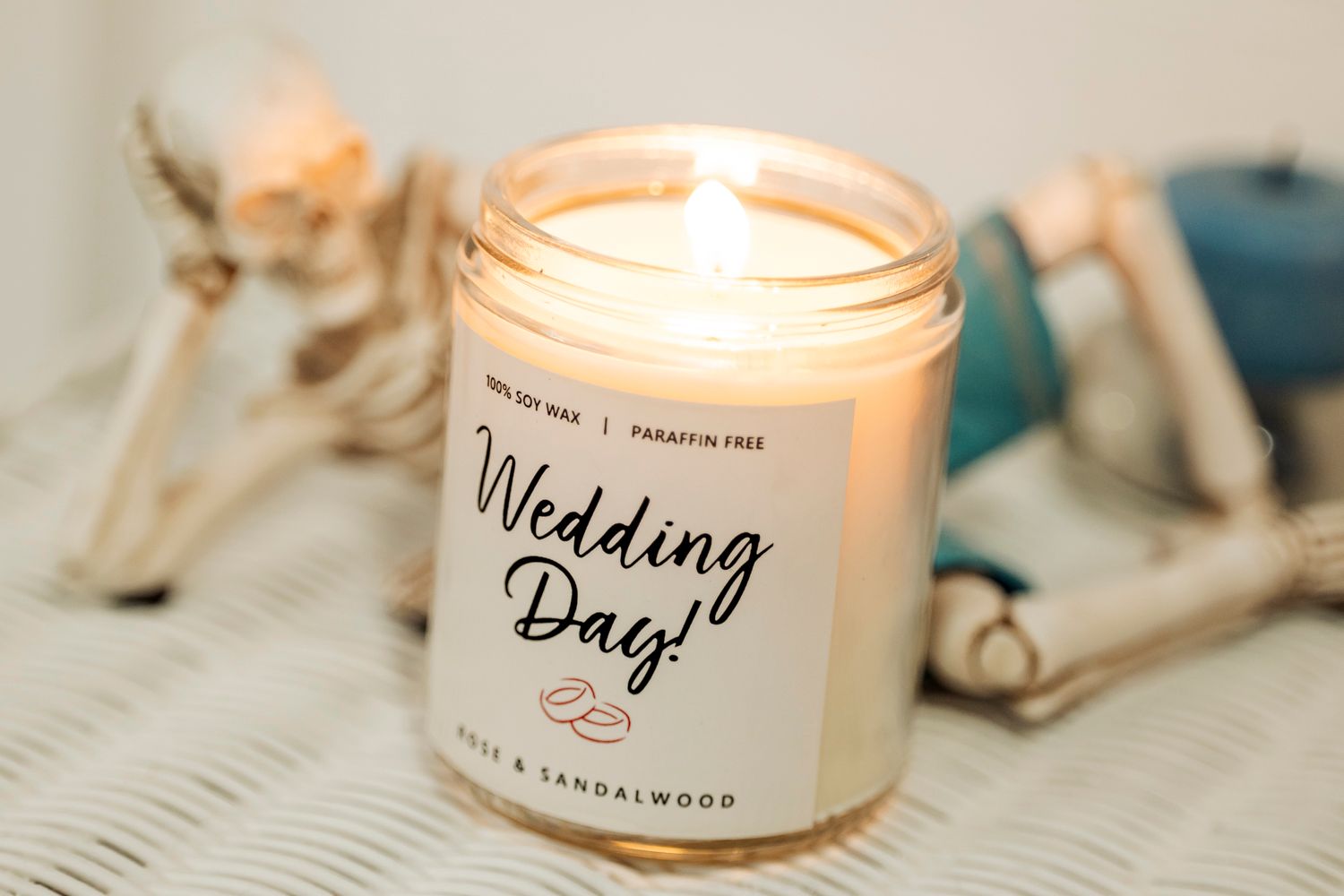 A lit 'Wedding Day!' scented candle in a glass jar with handwritten text.