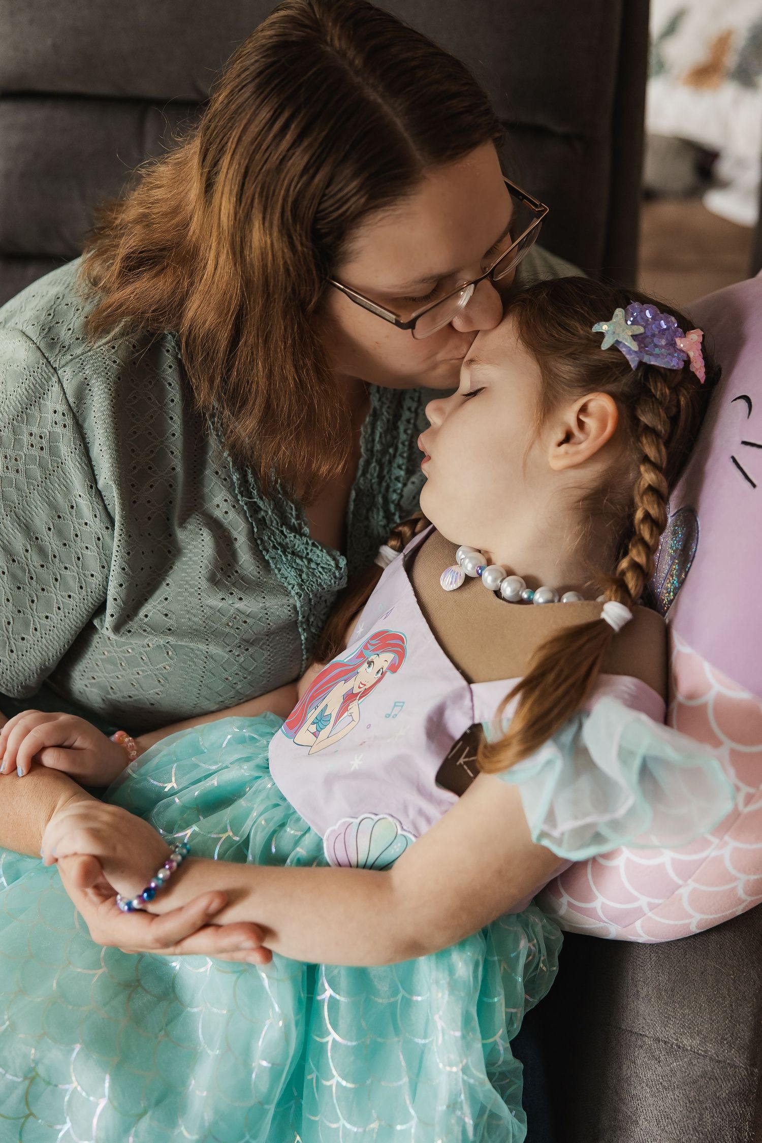 A series of tender moments showing a parent comforting and caring for their child in a mint green dress.