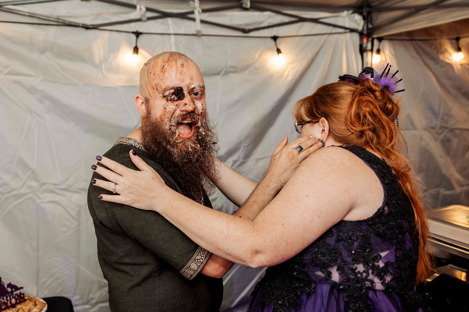 Playful moment between wedding guests sharing dessert at reception.