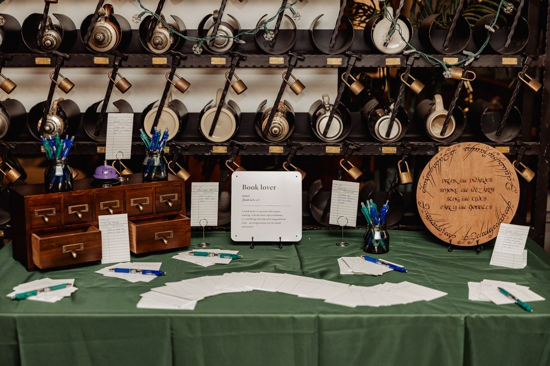 Wedding book table with green tablecloth, card catalog, and banjos displayed on wall behind.