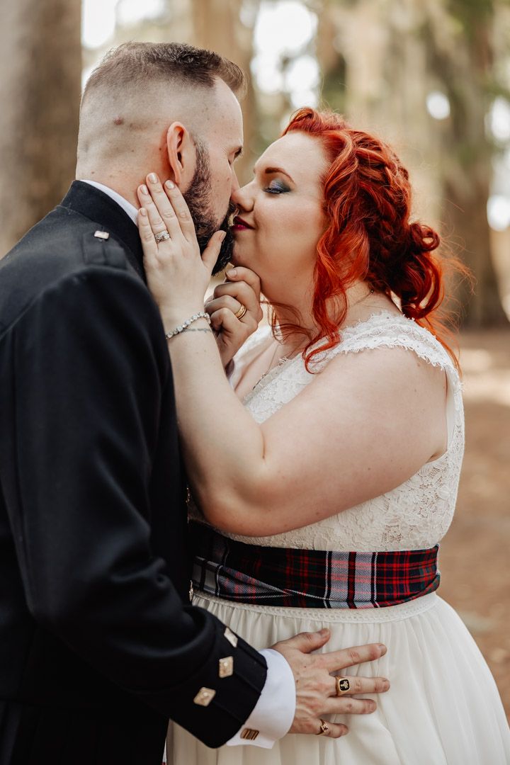 An intimate wedding moment captured between newlyweds sharing a romantic gesture.
