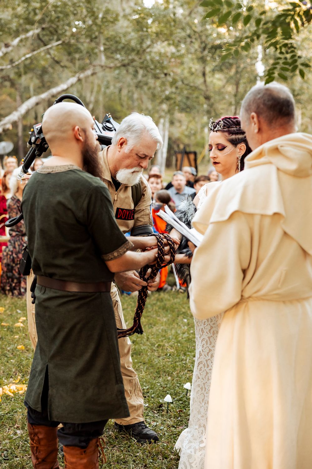 Medieval handfasting ceremony being performed outdoors with traditional costumes and clergy.