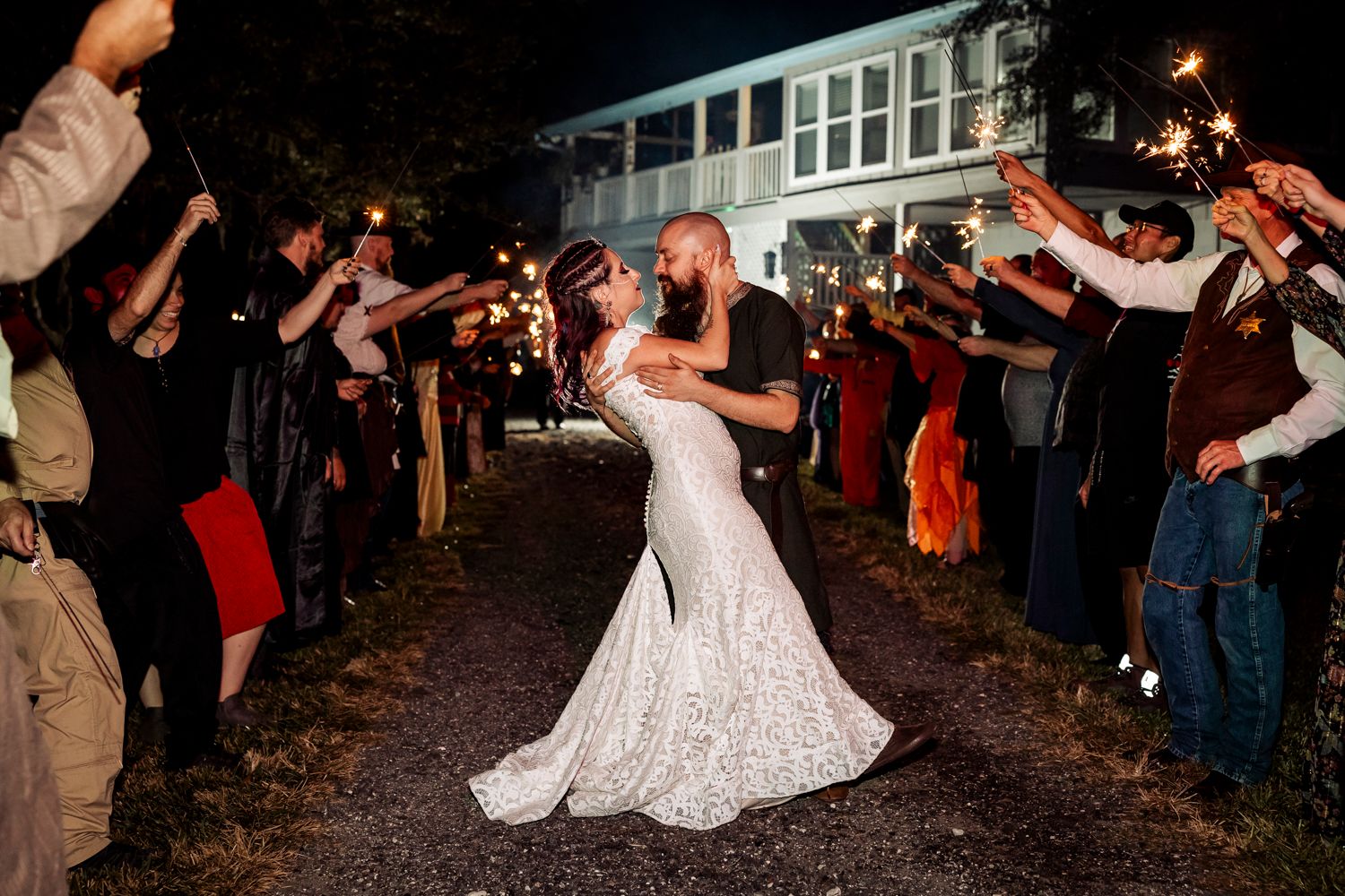 Wedding guests form a sparkler tunnel as a couple dances through during their evening celebration.