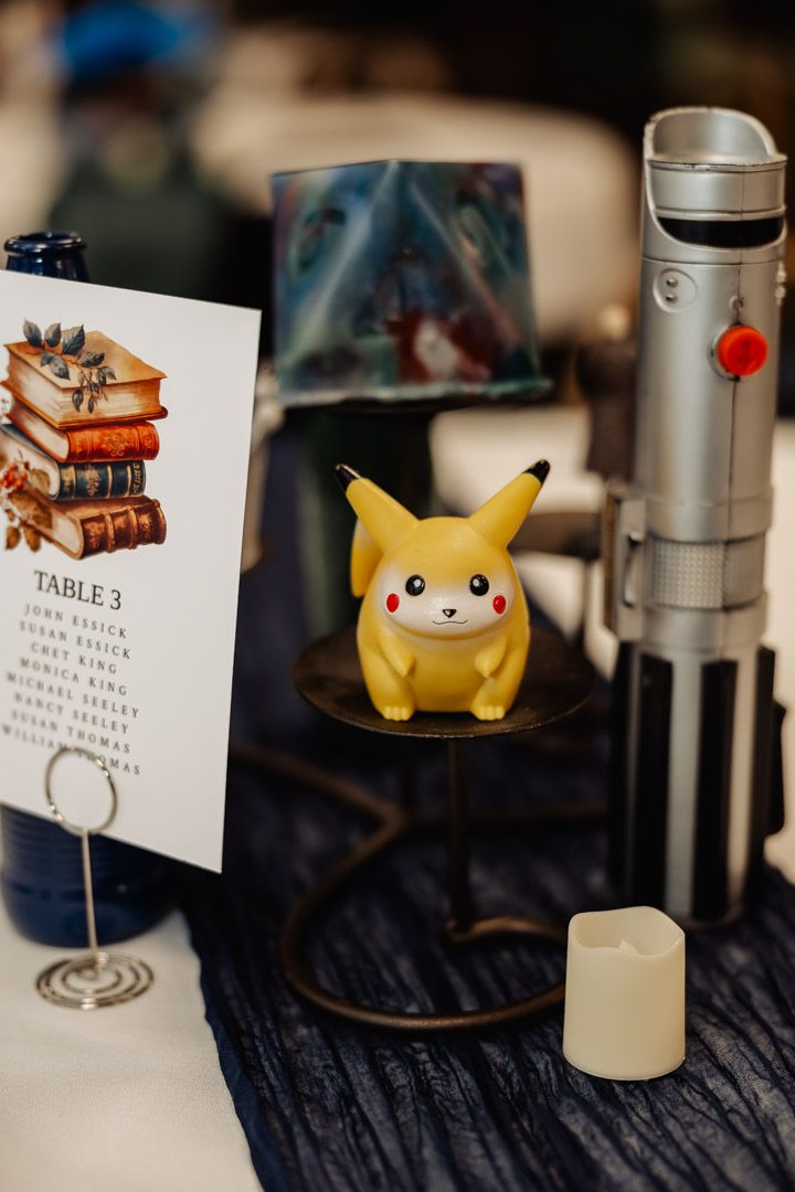 Table setting with Pikachu figurine, books artwork, and metal thermos.