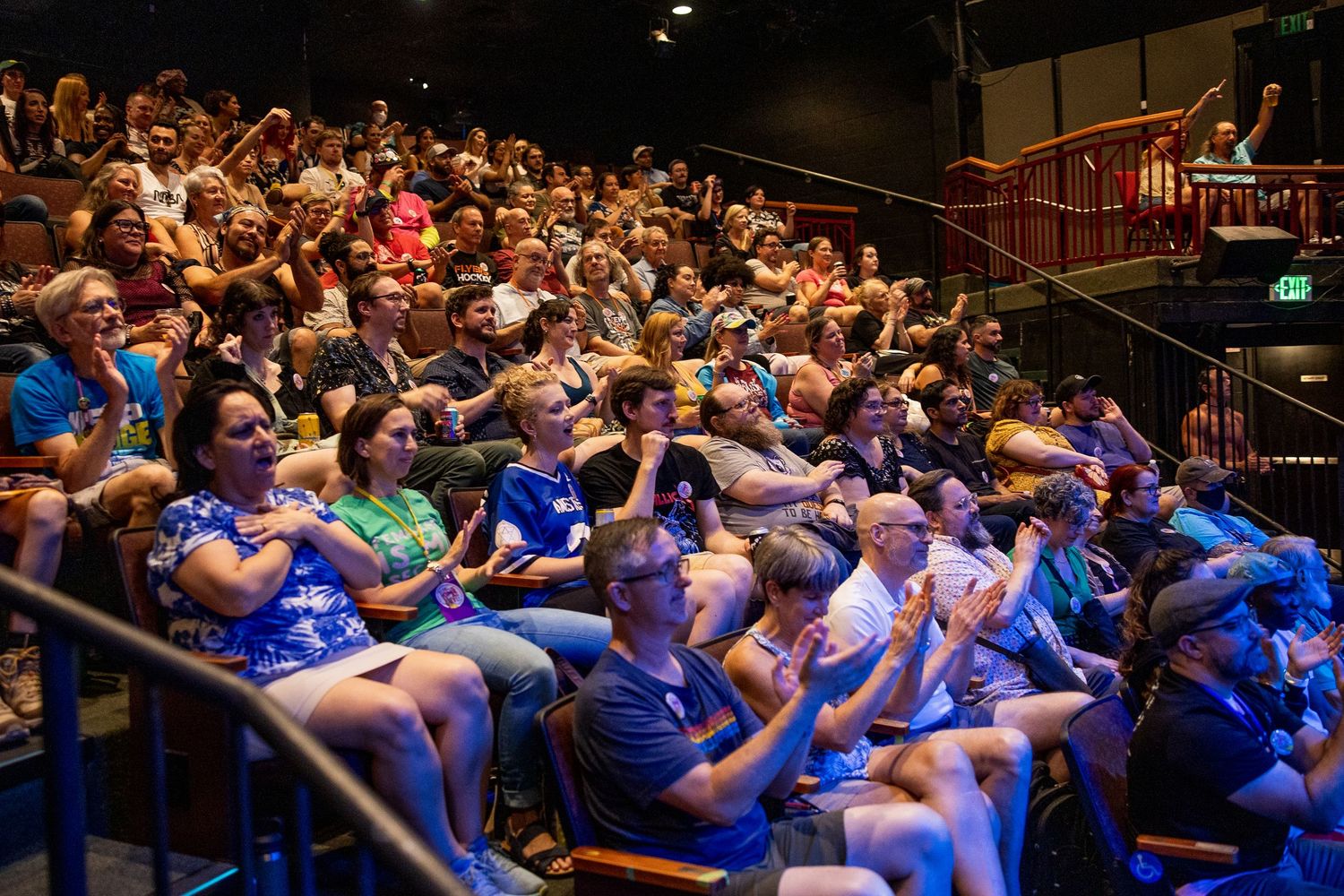 Enthusiastic audience applauding and cheering at a live burlesque theater performance.