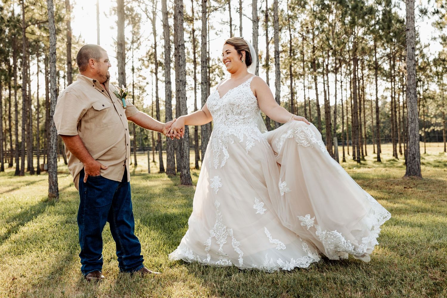 A playful moment between wedding couple dancing in a pine forest with beautiful afternoon light.