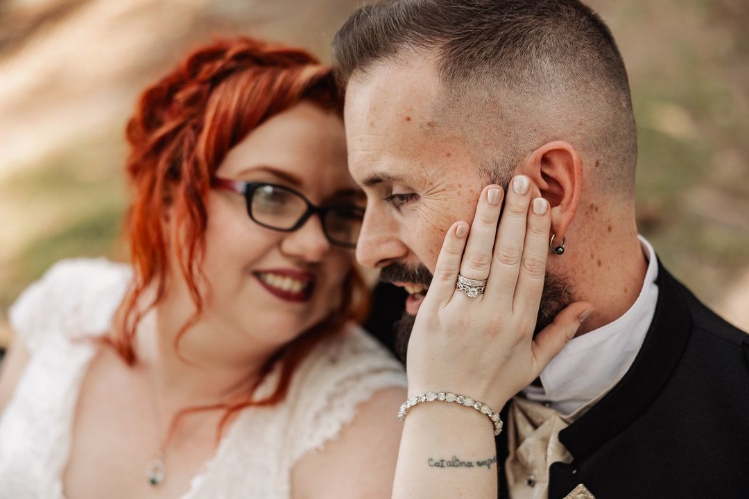 A joyful wedding portrait showing the couple sharing an intimate moment outdoors.