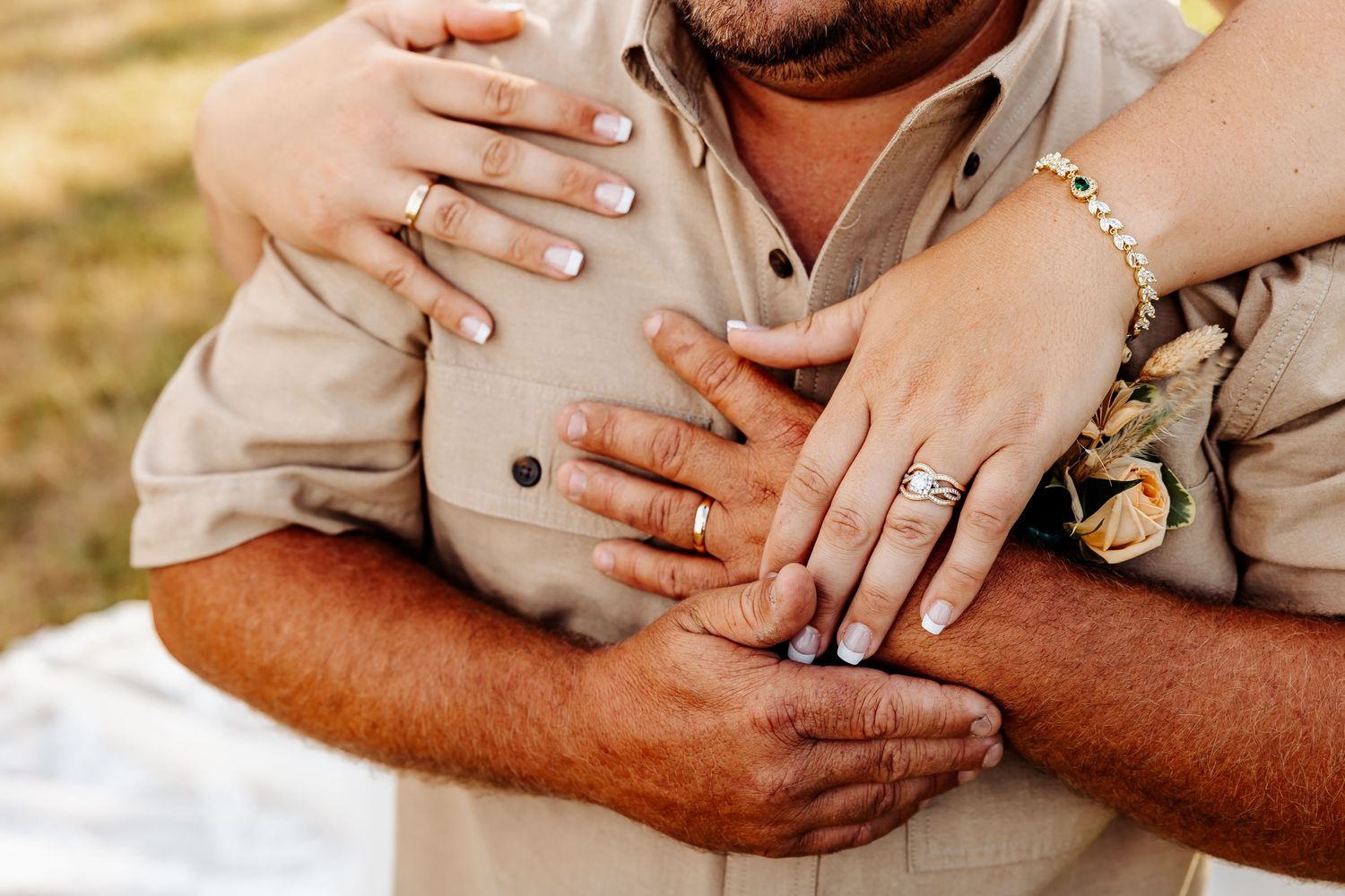 Close-up of hands with wedding rings and jewelry.