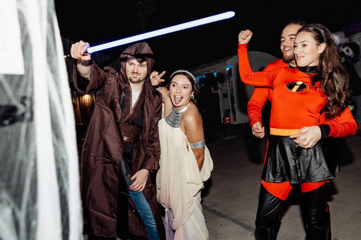 Wedding guests in Star Wars and Incredibles costumes dancing at a Halloween-themed wedding party.