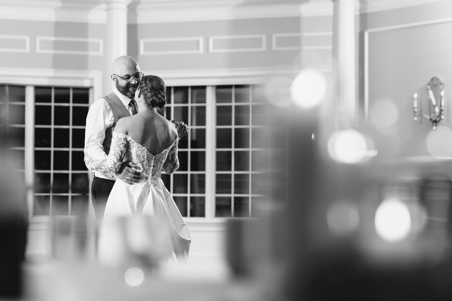 Bride and groom sharing an intimate first dance in black and white wedding photo.