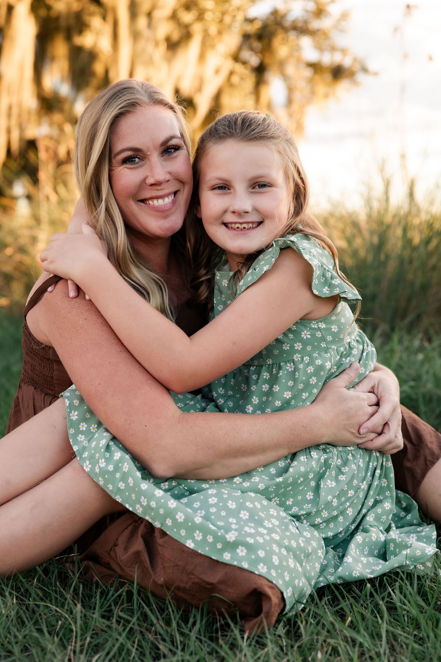 A loving embrace captured during an outdoor photo session with Spanish moss trees in soft lighting.