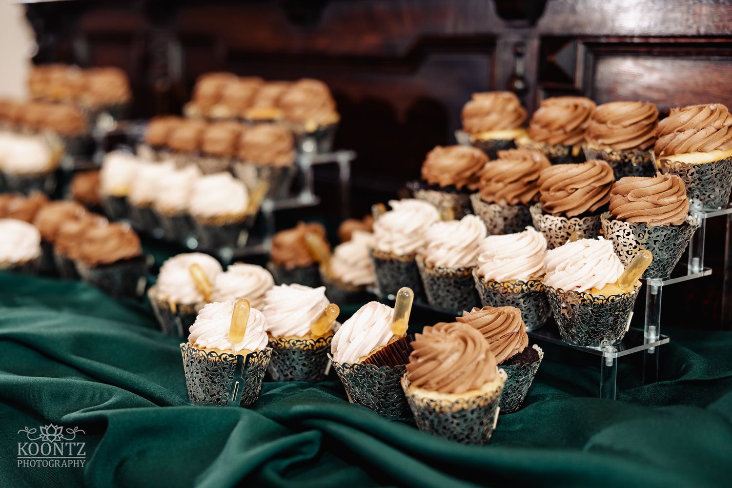Gourmet cupcakes with chocolate and vanilla frosting displayed on tiered stands.