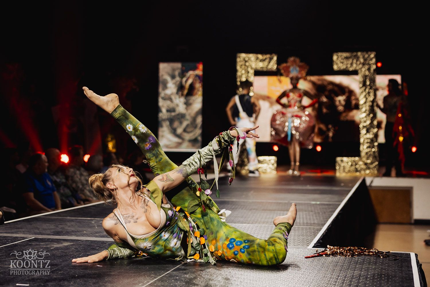 Dramatic dance performance on stage with colorful costumes and dynamic movement captured in action sequence.