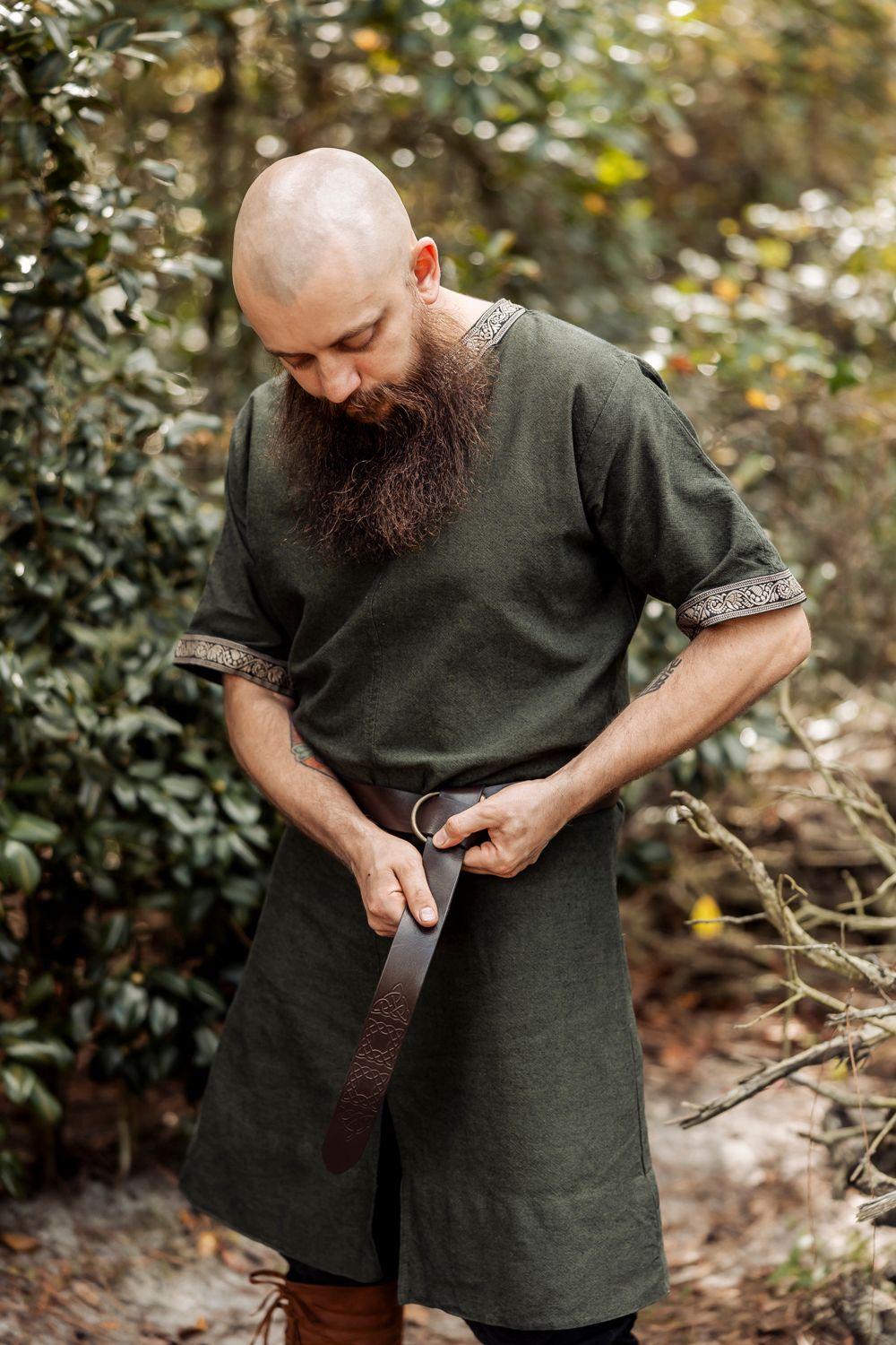 Medieval style green tunic worn outdoors with leather belt detail.