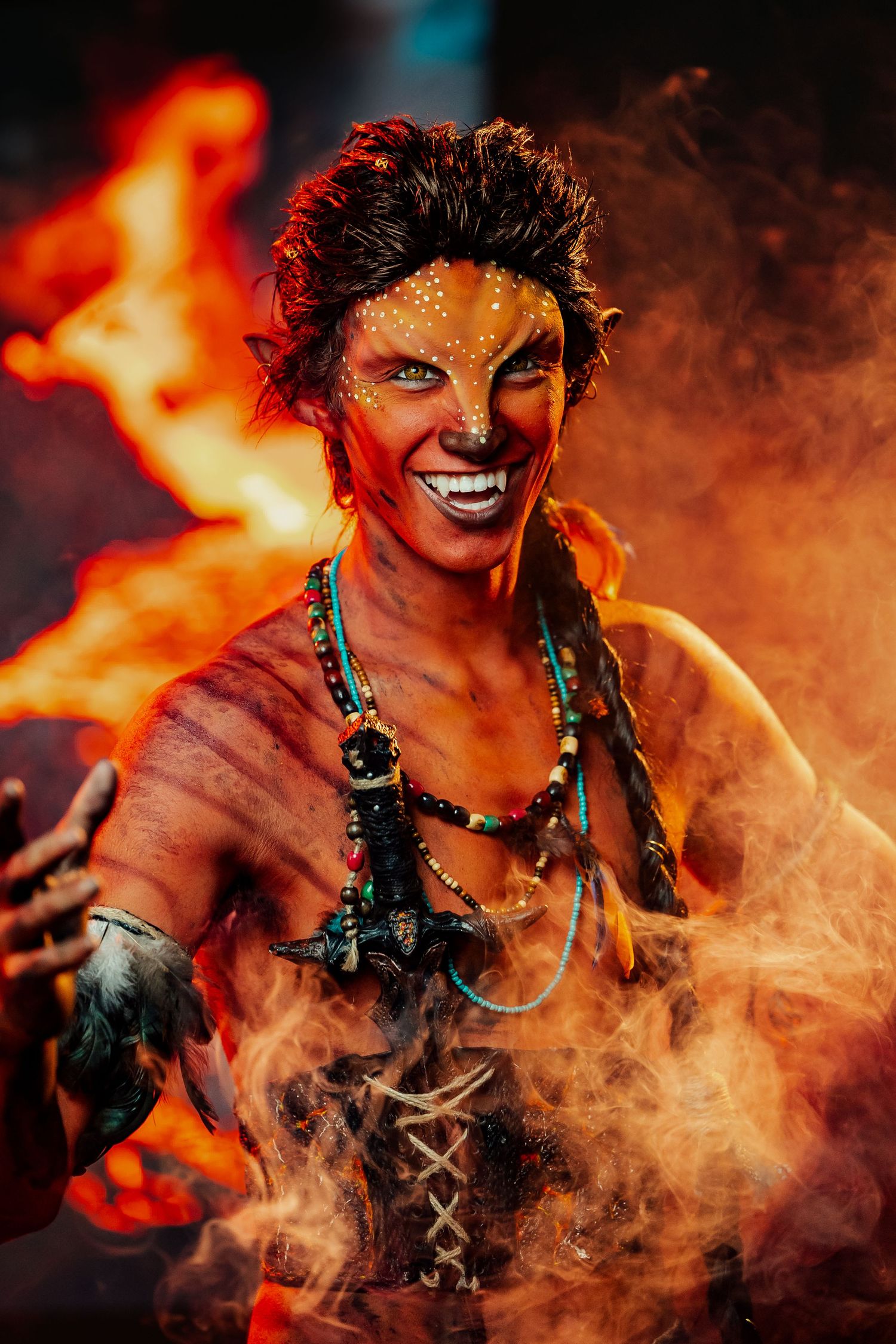 Fantasy character in fiery scene with dramatic lighting and special effects makeup against flames.