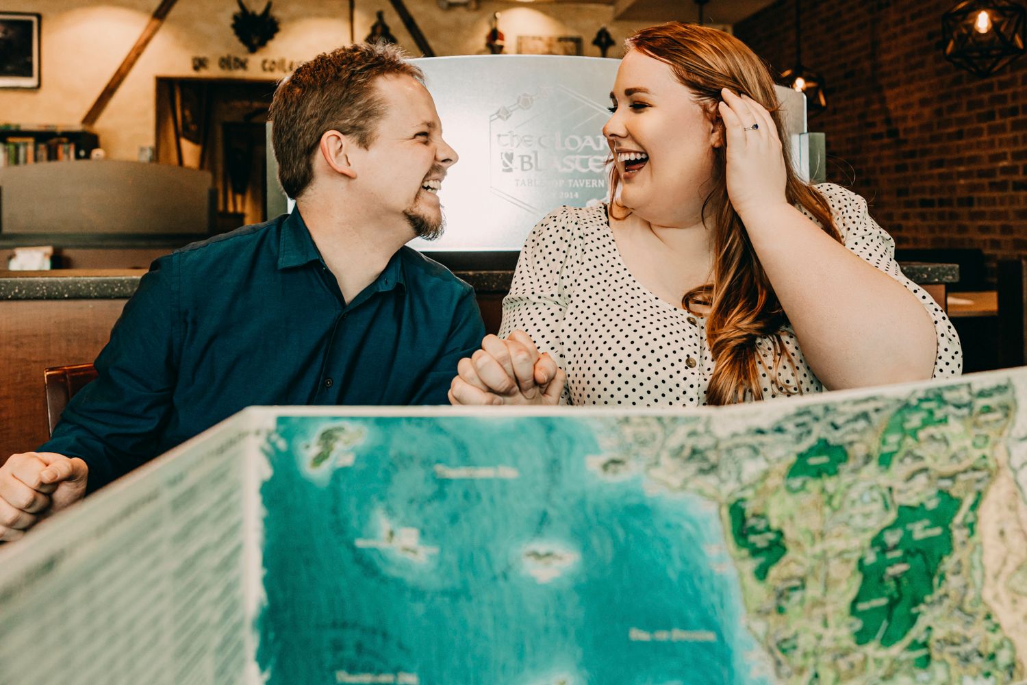 Happy couple looking at map together in casual cafe setting.