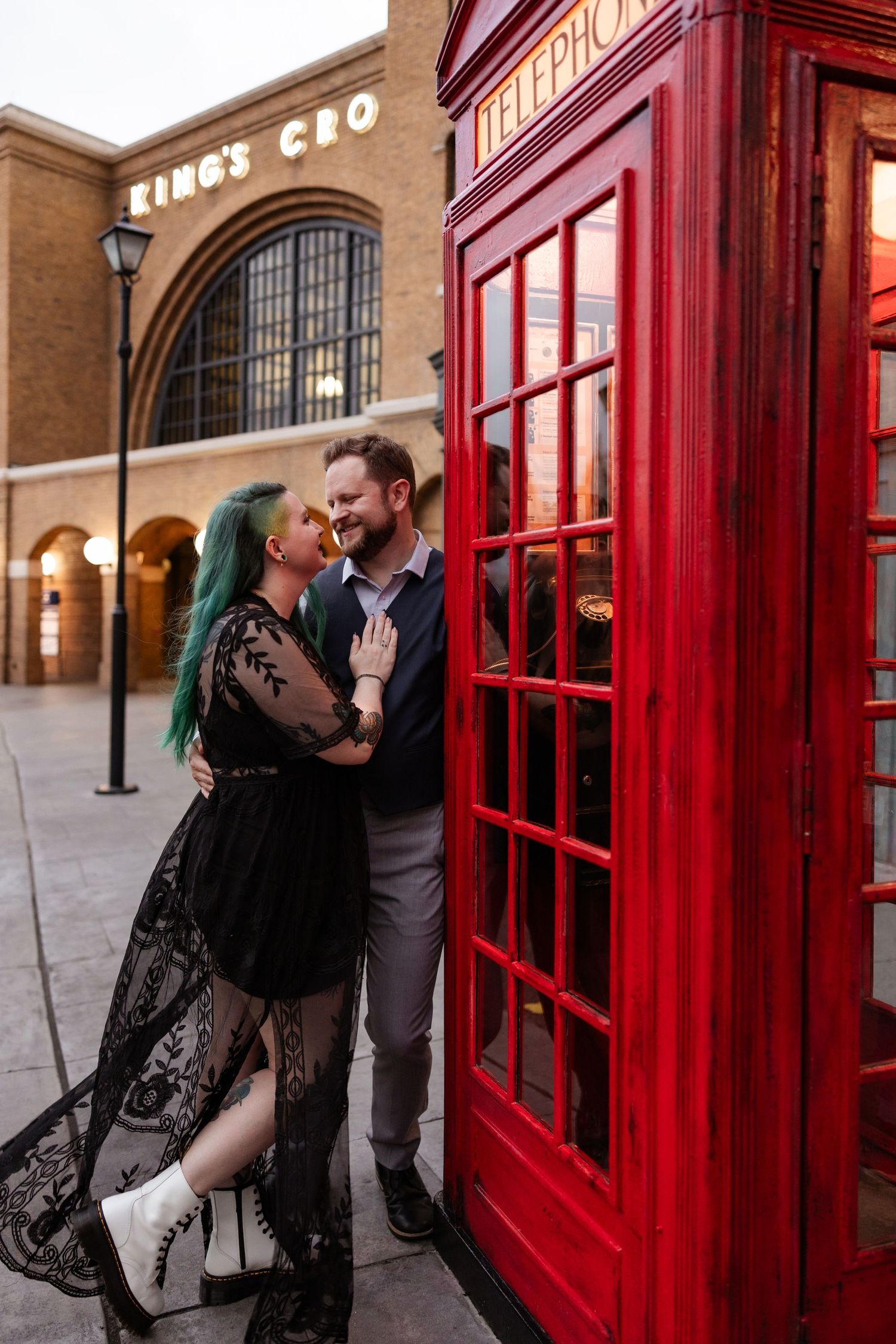 A romantic moment by a classic red British phone booth near Kings Cross Station.