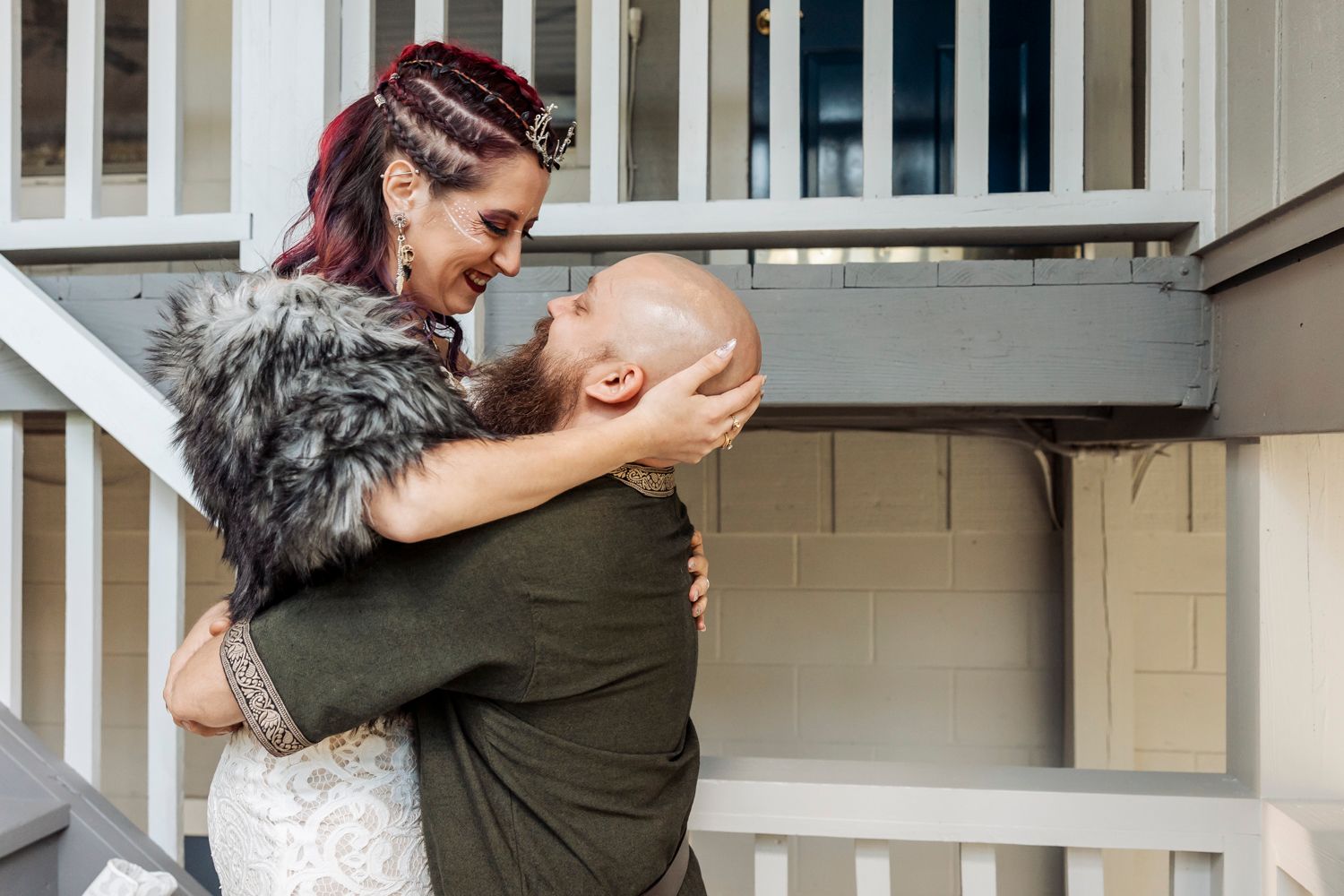 A tender embrace captured on a porch during a wedding celebration.