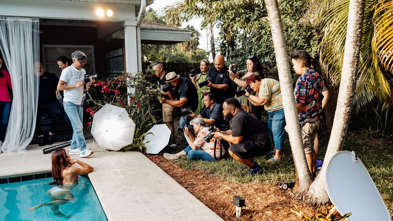 Group of photographers capturing shots around a swimming pool.