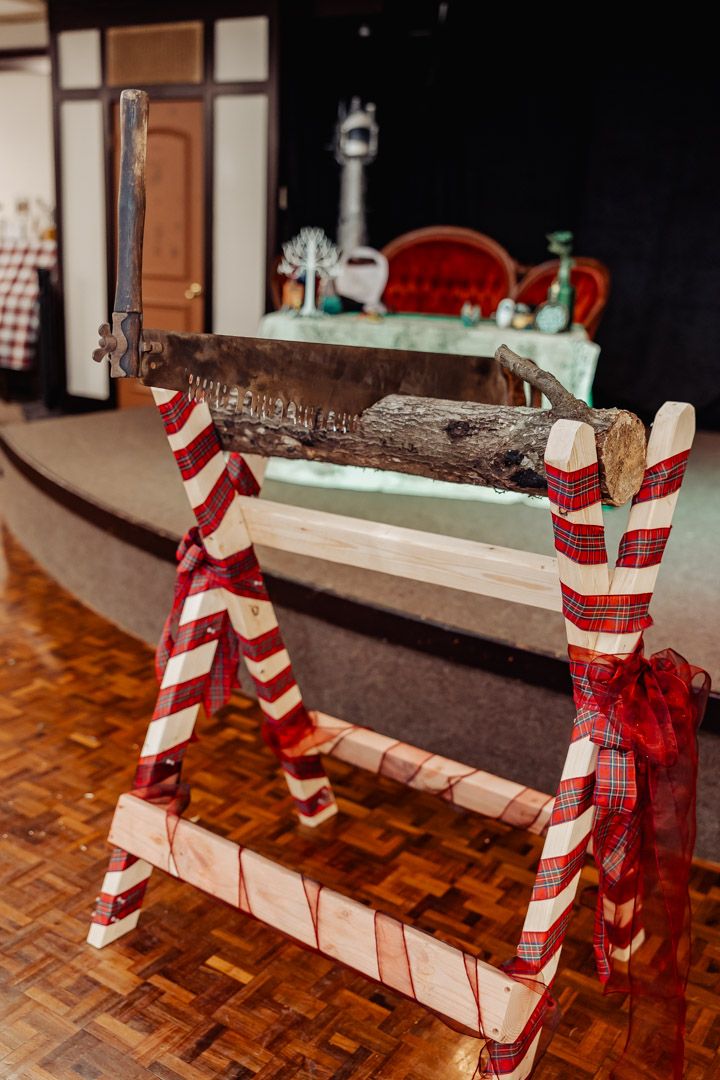 Red and white striped log holder made from candy cane themed posts on parquet floor.