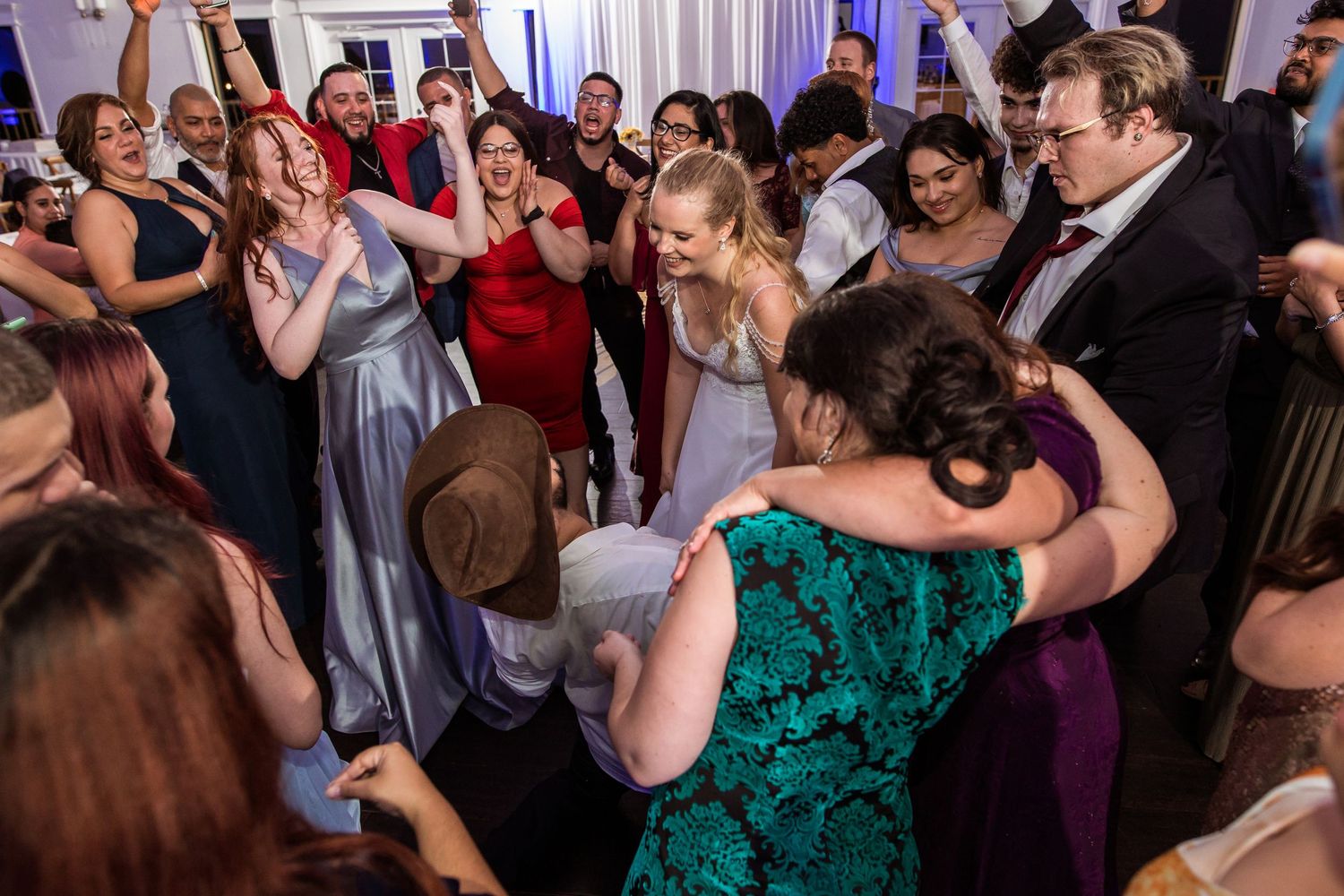 Guests dancing and celebrating joyfully at a wedding reception in an elegant venue.
