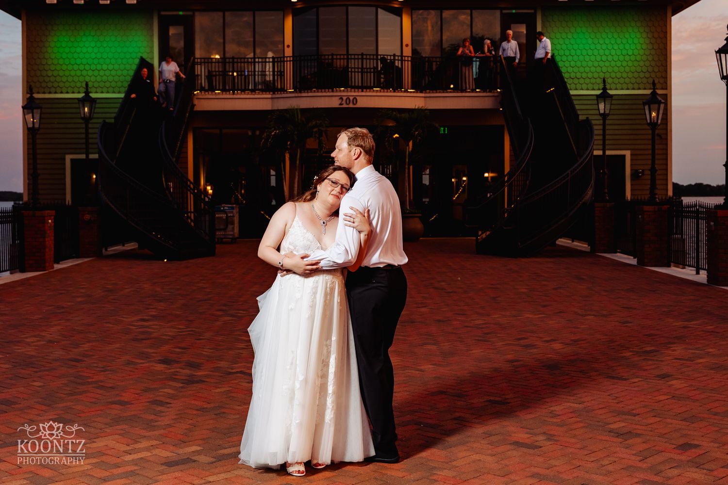 Intimate dance moment in an indoor venue with dramatic lighting and stage backdrop.
