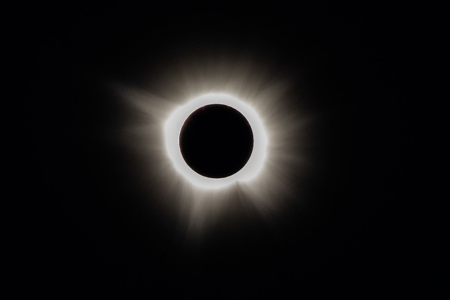 Dramatic total solar eclipse displaying bright corona against black sky.