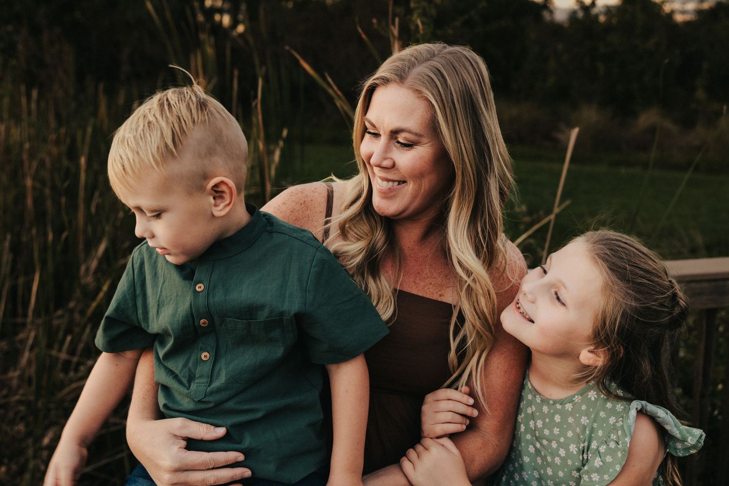Family sharing intimate moment together in natural outdoor setting during sunset.