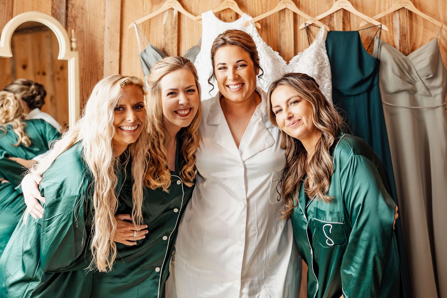 Wedding party in emerald green robes sharing joyful moment together.