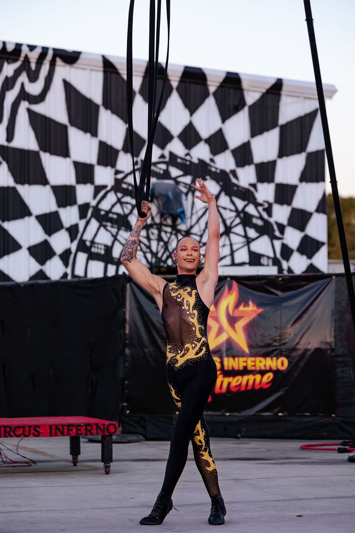 Female circus performer in black and gold costume posing on stage at Circus Inferno Extreme show.