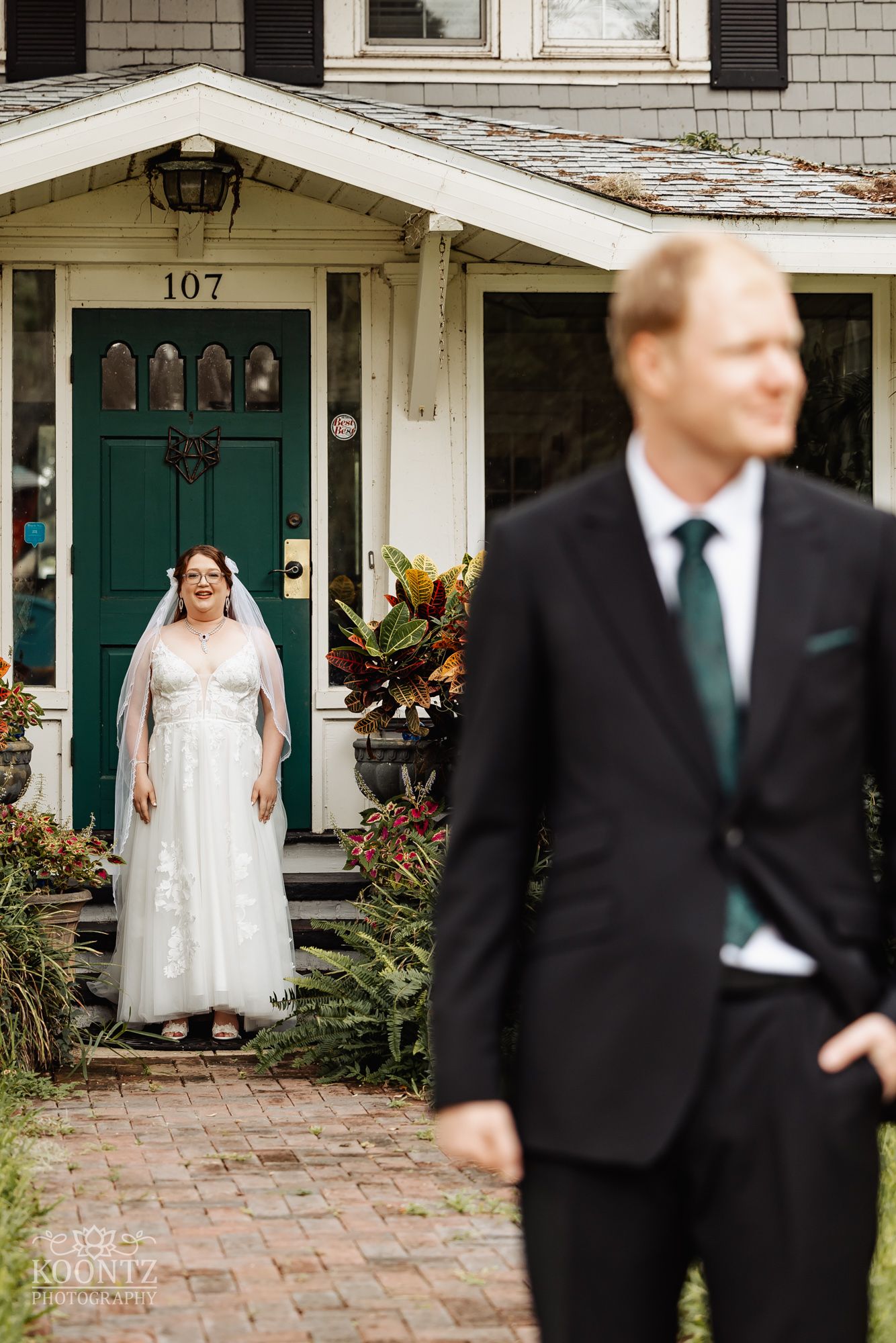 First look moment at a charming house with green door numbered 107.