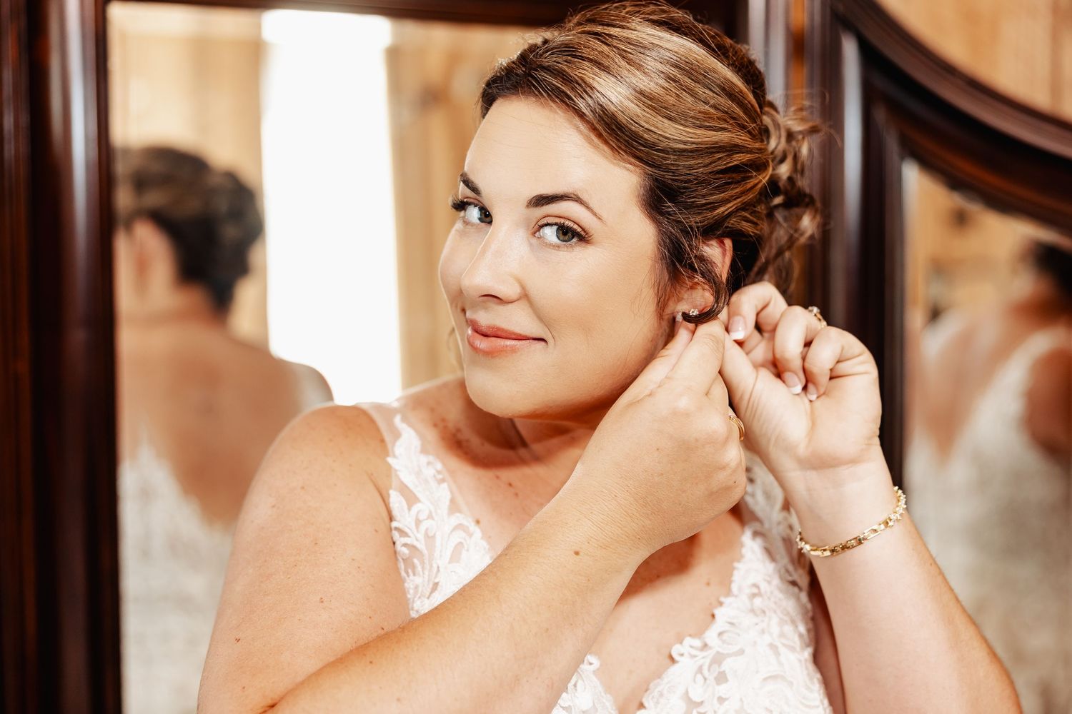 Delicate moment captured during bridal preparations with soft lighting.