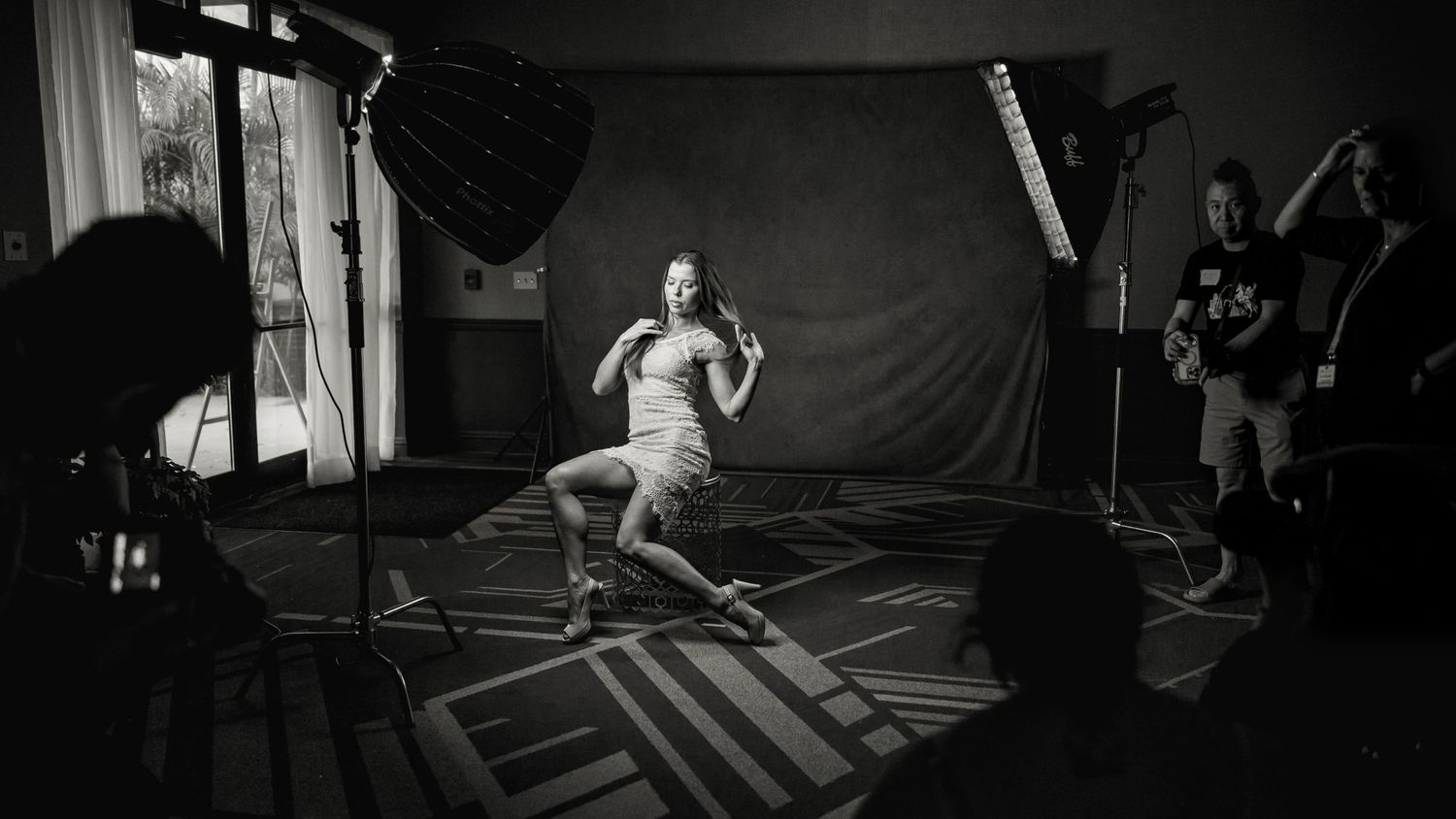 Behind the scenes of studio photoshoot with lighting equipment and photography team.