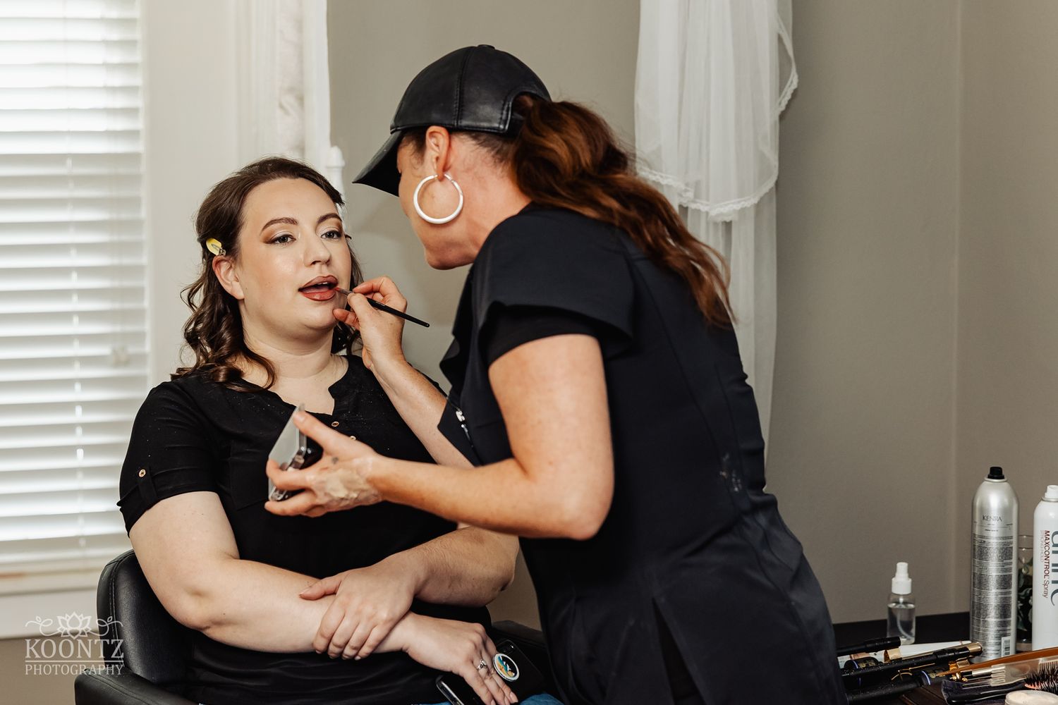 Professional makeup artist applying cosmetics in preparation for special event.