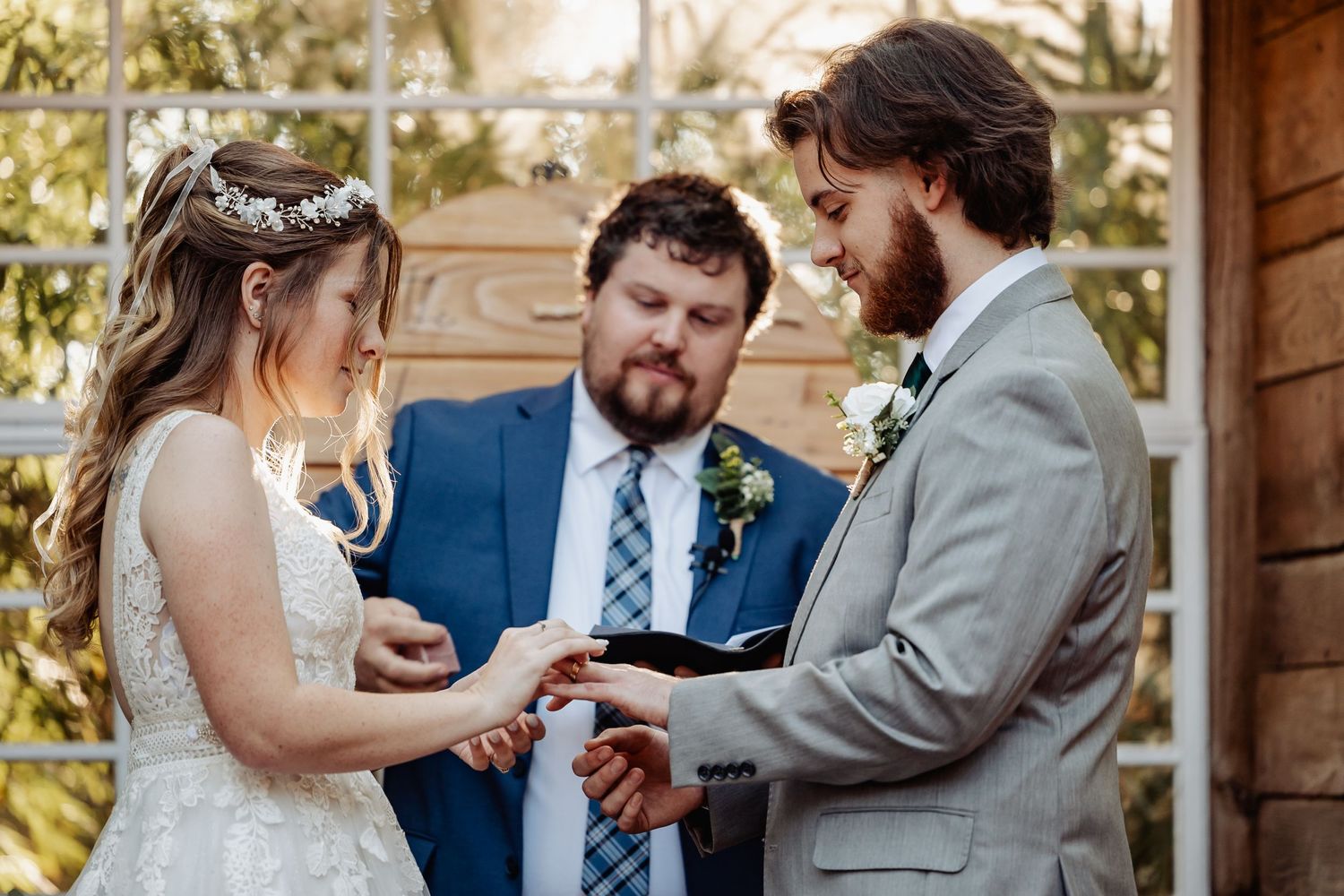 Wedding ceremony at rustic wooden altar with exchange of rings.