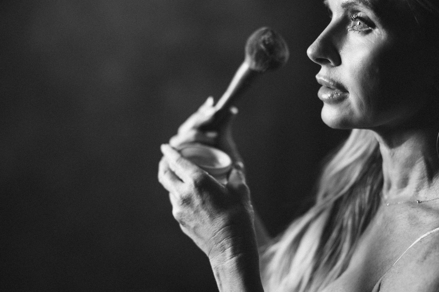 Intimate black and white portrait with dramatic side lighting and soft focus.