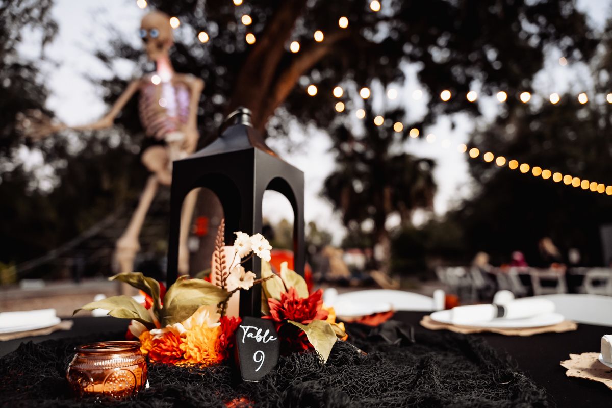 Evening wedding reception table setting with string lights and candlelit decor.