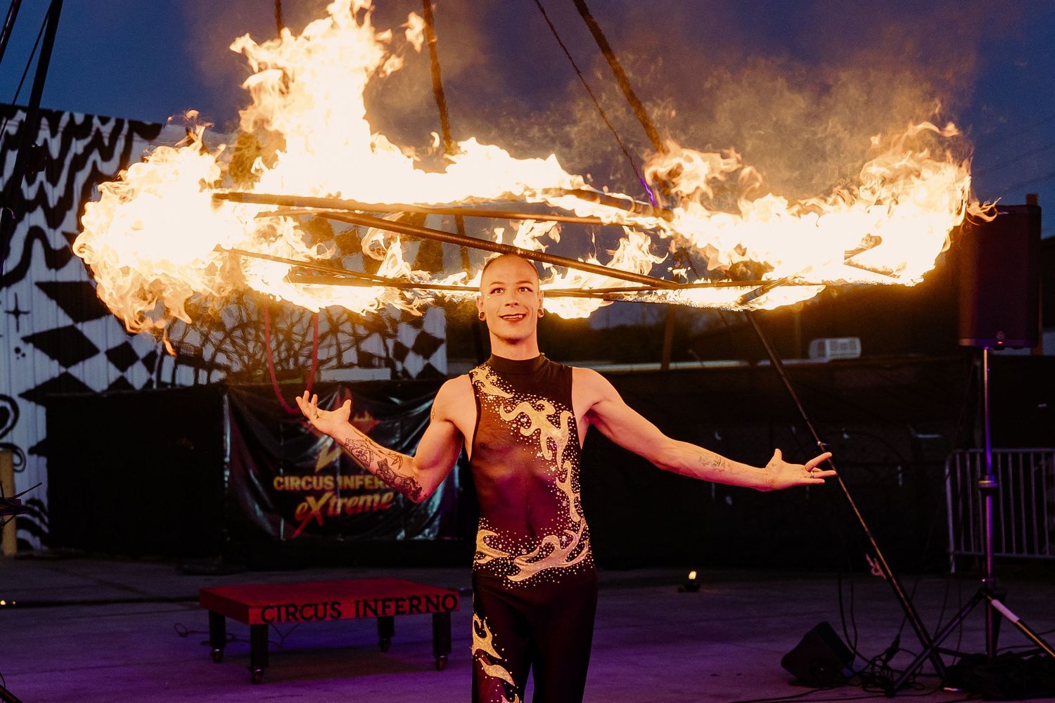 Female circus performer balancing a large fire staff on stage at Circus Vargas Xtreme show.