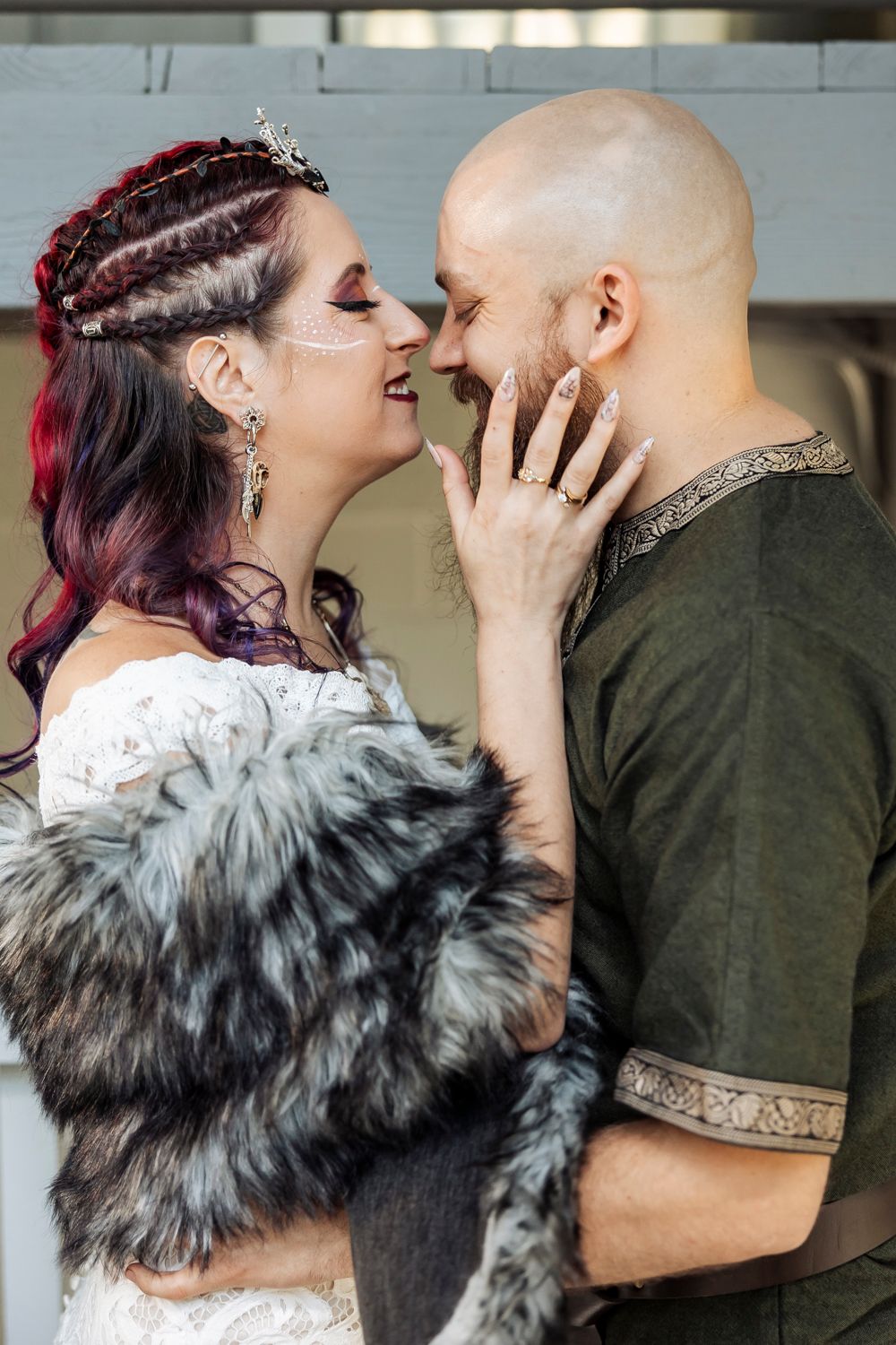 A joyful couple laughs together during an intimate moment while dressed in wedding attire.