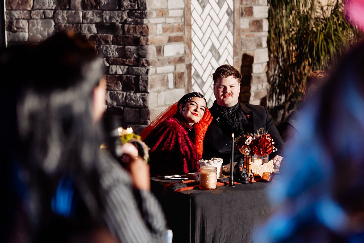 Artistic wedding photography against a brick wall with dramatic lighting and blue accents.
