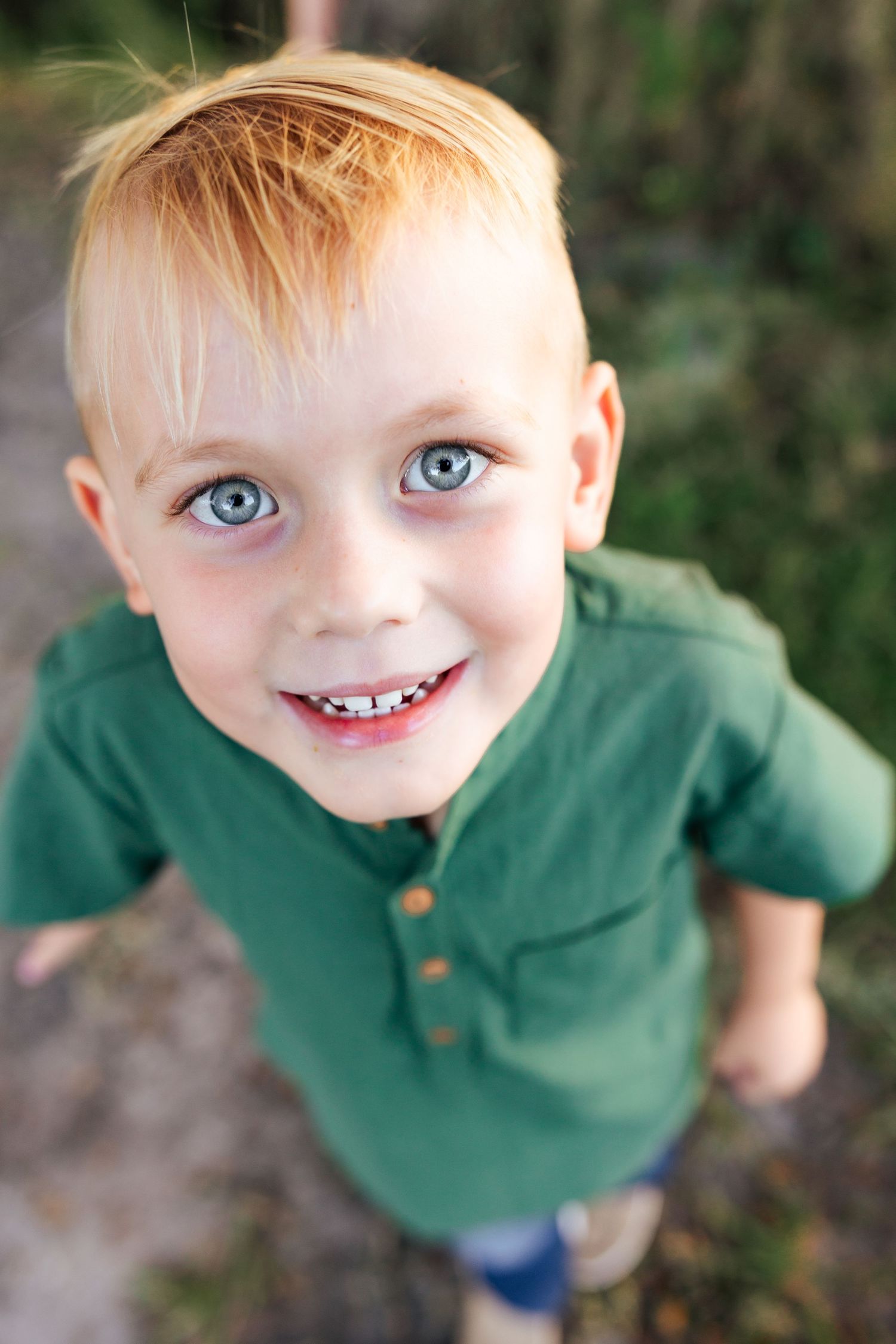 Close up portrait with bright blue eyes and green shirt.