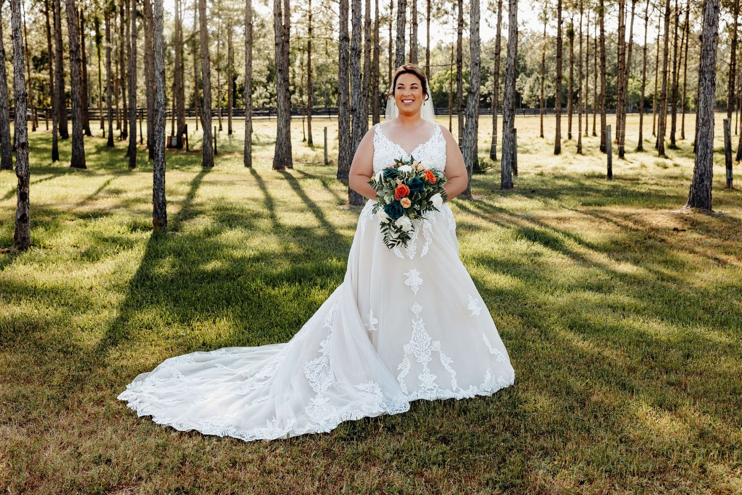 Wedding photography in a sunlit pine forest with long shadows.
