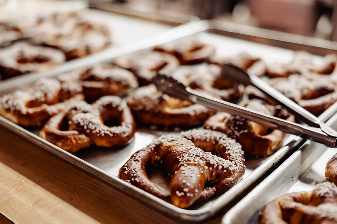 Fresh baked chocolate covered pretzels arranged on metal baking sheet.