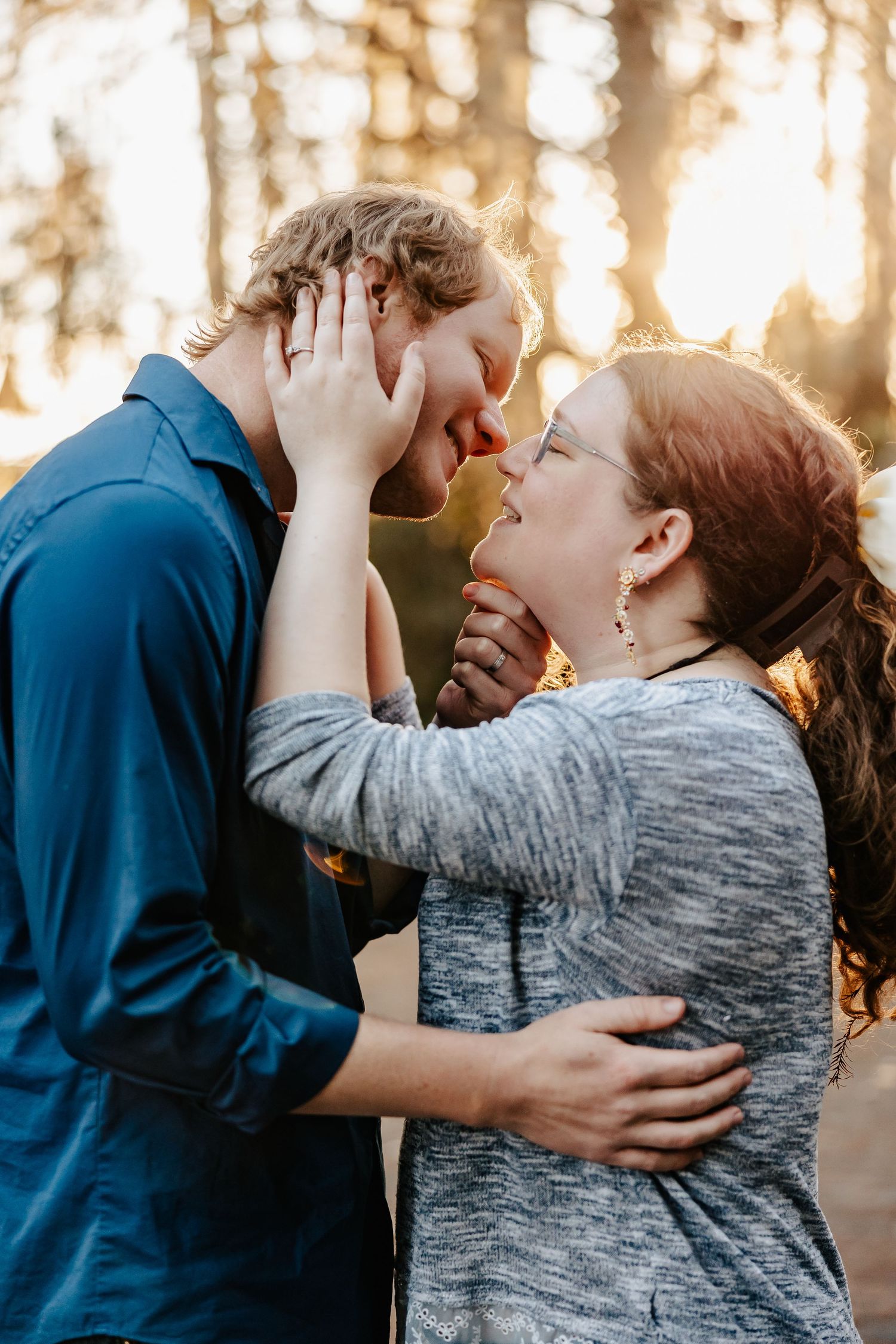 Romantic couple almost kissing at golden sunset, woman holding mans face tenderly.