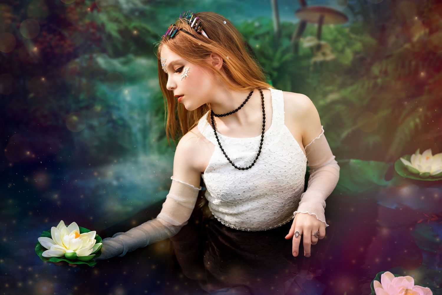 A young redhead woman reaches for a white lotus flower in a mystical enchanted forest pool setting.