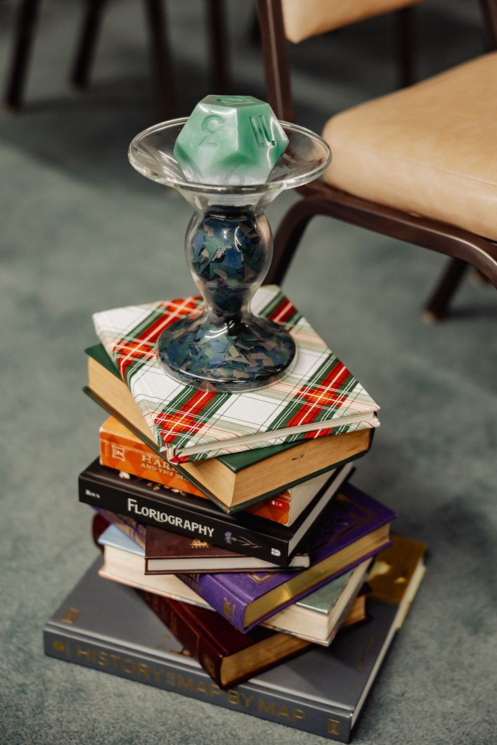 A decorative glass item sits atop a stack of vintage books with plaid patterns.