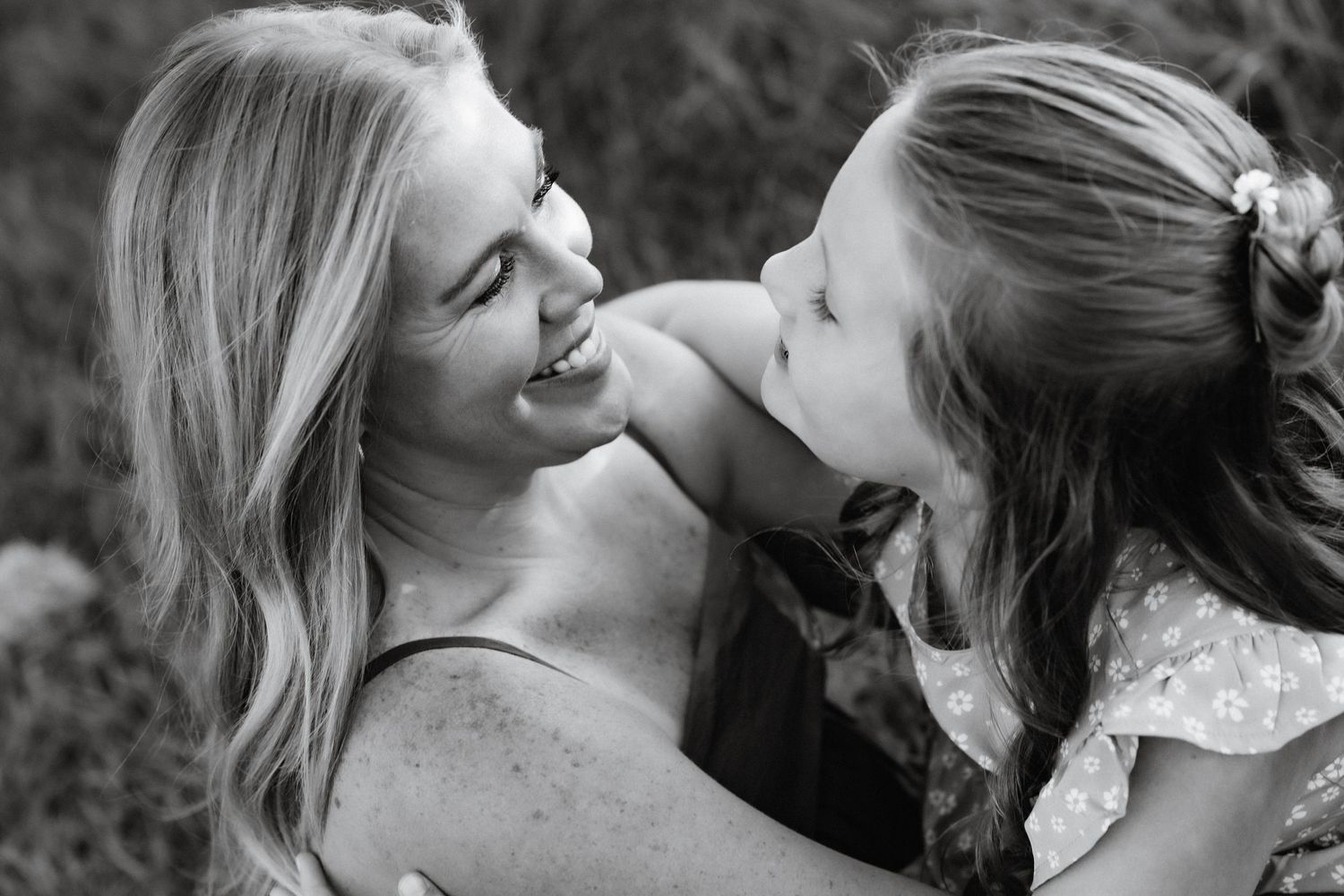 A black and white intimate portrait showing genuine joy and connection outdoors.